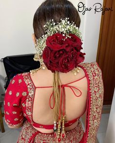 the back of a woman's dress with flowers in her hair