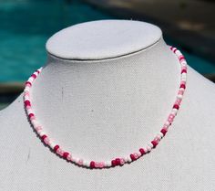 a pink and white beaded necklace on a mannequin