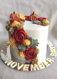 a white cake with red and yellow flowers on it