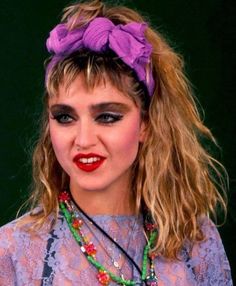 a close up of a person wearing a necklace and a headband with beads on it