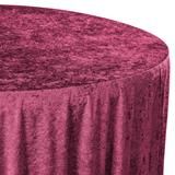 a round table covered with a pink crushed velvet cloth, sitting on a white background