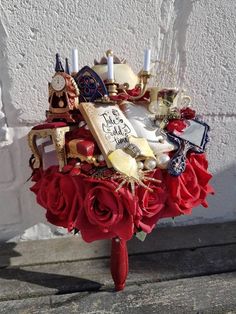 a bouquet with candles and other items on it sitting next to a wall in front of a building