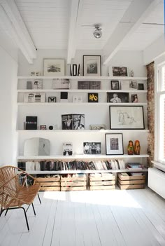 a white room with bookshelves and pictures on the wall