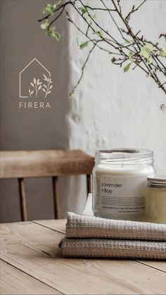 a jar of lavender body scrub sitting on top of a wooden table next to a vase with flowers