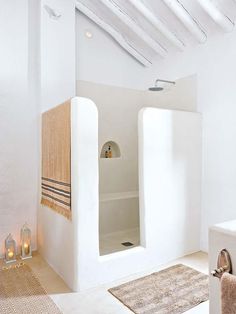 a bathroom with a shower and rugs on the floor