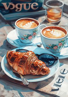 two cups of coffee and croissants on a table next to each other