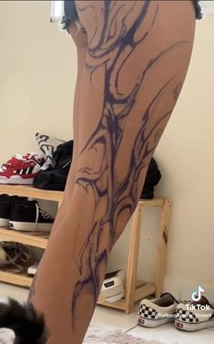 a woman's legs with tattoos on them