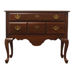 a wooden dresser with four drawers and gold knobs on the top, against a white background