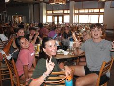 a group of people sitting around a table with food and drinks in front of them