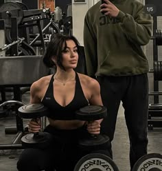 a woman sitting on top of a bench with two dumbs in front of her