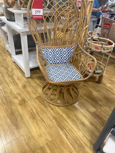 a wicker rocking chair with blue and white pillows on display in a furniture store