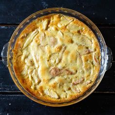 a casserole with meat and cheese in a glass dish on a wooden table