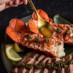 a person is spooning some food on a plate with lobsters and broccoli