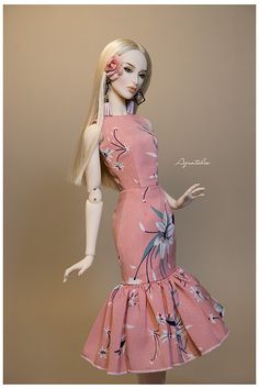 a barbie doll wearing a pink dress with flowers on it