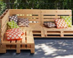 a bench made out of wooden pallets with pillows on it