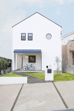 a white house with a bicycle parked in the driveway