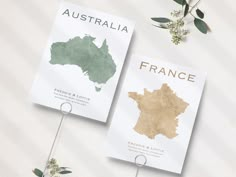 two brochures with the names of france and australia on them next to some flowers