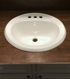 a white sink sitting on top of a wooden counter