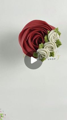 a red and white rose with green leaves on it's head is flying through the air