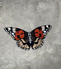 an orange and black butterfly painted on concrete