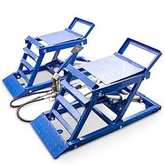 two blue work benches sitting next to each other on top of a white surface with a hose connected to it