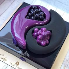 a purple and black cake with blueberries on it