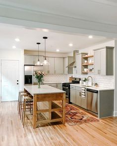 a kitchen with an island, sink and stove top oven next to a dining room table