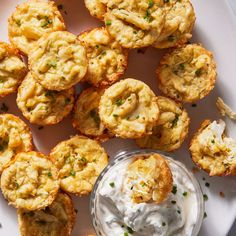 small appetizers on a white plate with a bowl of ranch dressing next to them