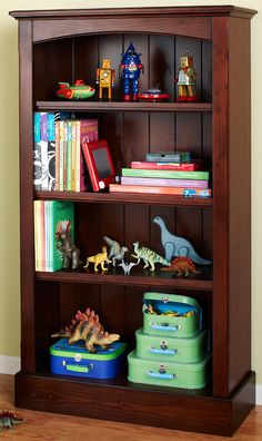 a bookshelf with toy dinosaurs and other toys