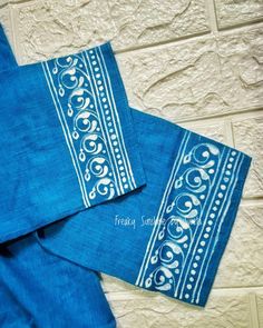 three blue napkins with white designs on them