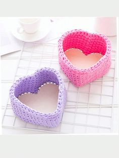 two heart shaped baskets sitting on top of a table