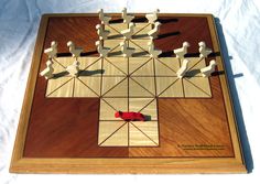 a wooden board game with pieces arranged on it