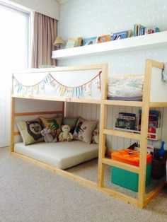 a child's bedroom with bunk beds and bookshelves in front of the window