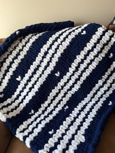 a blue and white crocheted blanket sitting on top of a couch