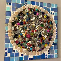 a tree made out of many different items on a mosaic tile wall mounted above a toilet