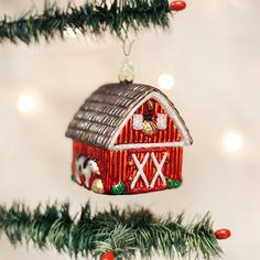 a red barn ornament hanging from a christmas tree