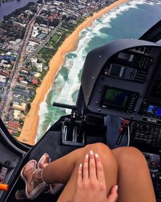 a woman is sitting in the cockpit of an airplane looking at the beach and ocean