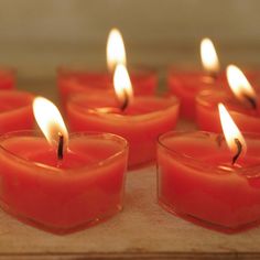 many candles are lit in rows on a table