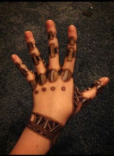 a person's hand covered in hendigns and bracelets on carpet