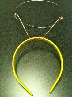 a pair of yellow wire hang from a hook on a black counter top with a green background