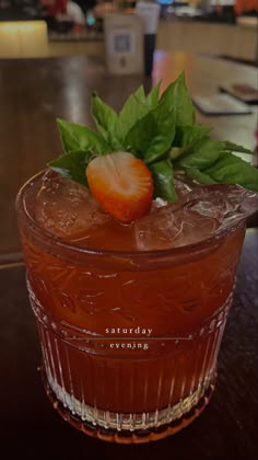 a close up of a drink with strawberries on the top and leaves in it