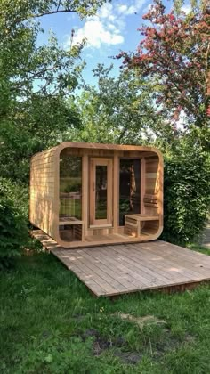 a wooden structure sitting on top of a lush green field