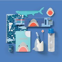 an assortment of stationery items displayed on a blue background, including a water bottle and toothbrushes