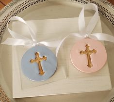 two cookies decorated with gold crosses on top of a plate