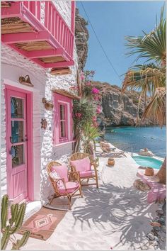 a pink and white house next to the ocean