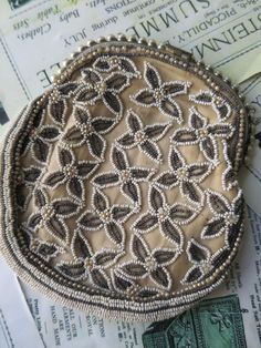 A lovely antique Art Deco evening bag with a floral design worked in glass beads with faux pearl beads to the centres. The bag opens to the top with a faux pearl gilt clasp. The bag has side gussets which are also beaded. The handle of the bag was a chatalaine chain to the back which has snapped. The bag has ivory silk lining. The beadwork is in very good condition. The front of the clasp that lifts up to open the bag has snapped off, a small piece remains which serves to open the bag. The measurements are; 5.5 x 6.5  inches/ 14 x 16.5 cm The handle measures; Art Deco Clutch, Pearl Clasp, Art Deco Floral, Tapestry Kits, Beaded Evening Bags, Ivory Silk, Deco Floral, Chatelaine, Antique Art Deco