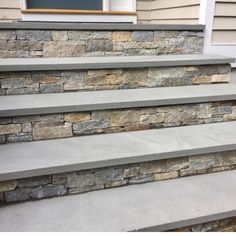 a set of stone steps leading up to a front door on a home's porch