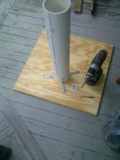 a drill and screwdriver sitting on top of a piece of plywood