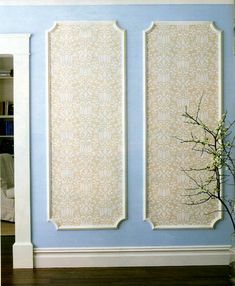 a room with blue walls and two white panels on the wall next to a plant