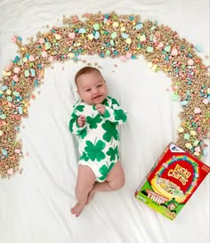 a baby laying on its back next to a box of cereal